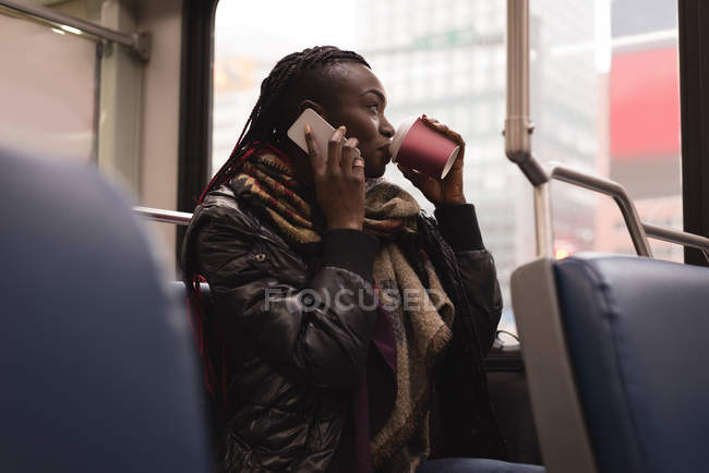 Молода жінка розмовляє по мобільному телефону під час подорожі в поїзді — стокове фото