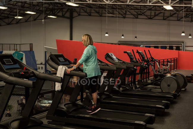 Behinderte ältere Frau trainiert auf Laufband im Fitnessstudio — Stockfoto