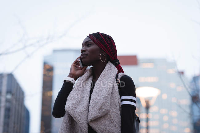 Woman talking on mobile phone in the city — Stock Photo