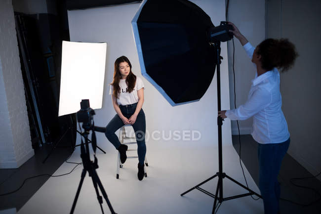 Modelo femenino posando para una sesión de fotos en un estudio fotográfico - foto de stock