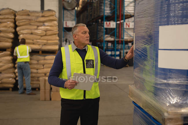 Superviseur masculin vérifiant le stock en entrepôt — Photo de stock