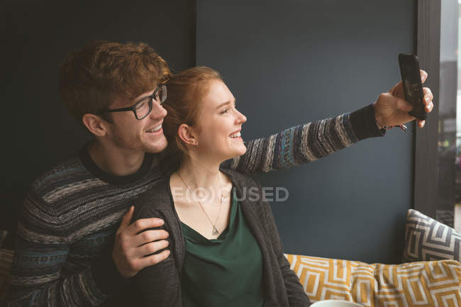Romantic couple taking a selfie in the cafe — Stock Photo