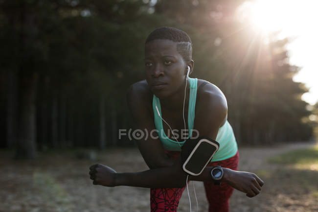 Deportista femenina decidida a escuchar música mientras hace ejercicio matutino - foto de stock