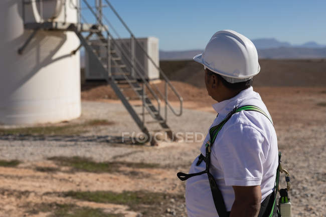 Інженер стоїть біля вітрового млина на вітроелектростанції — стокове фото