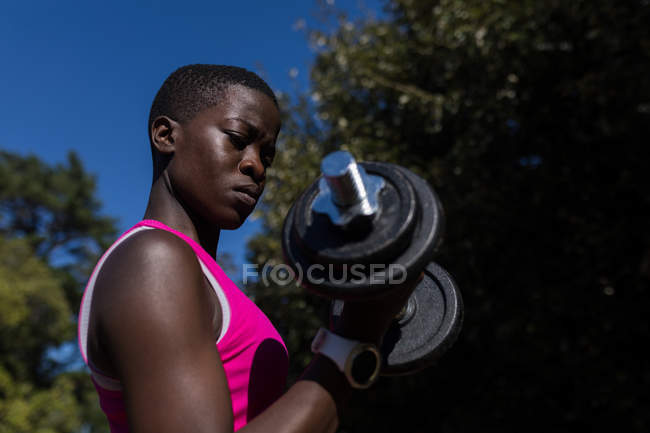 Крупный план женщины-спортсмена с гантелями — стоковое фото