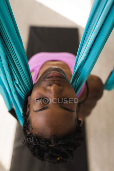 Woman exercising on swing sling hammock at fitness studio — Stock Photo