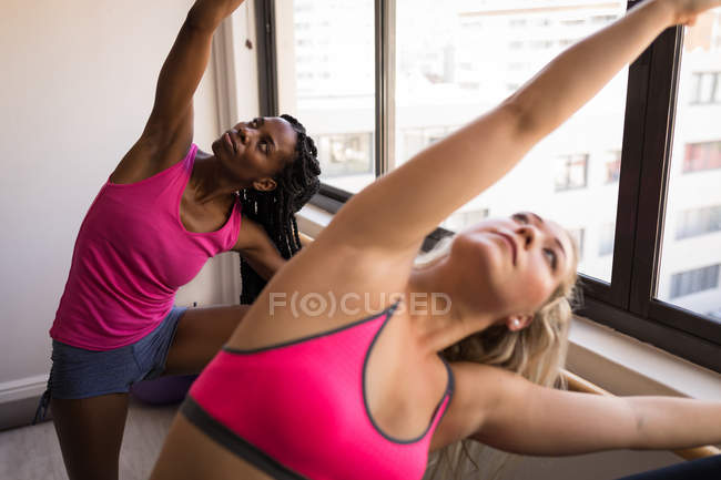 Duas mulheres realizando exercício de barro no estúdio de fitness — Fotografia de Stock