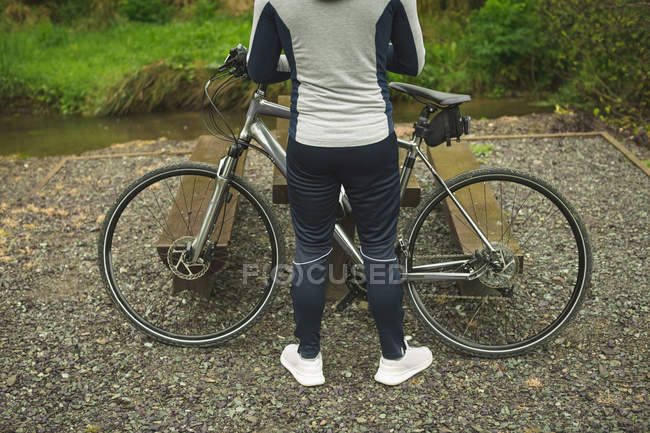 Вид сзади велосипедиста, стоящего с велосипедом — стоковое фото