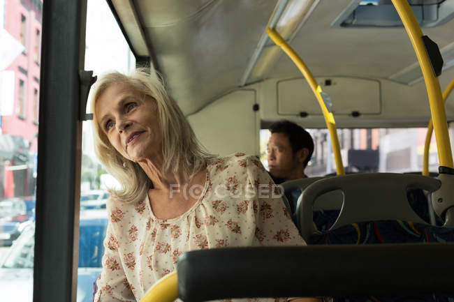 Продумана старша жінка, яка подорожує в автобусі — стокове фото