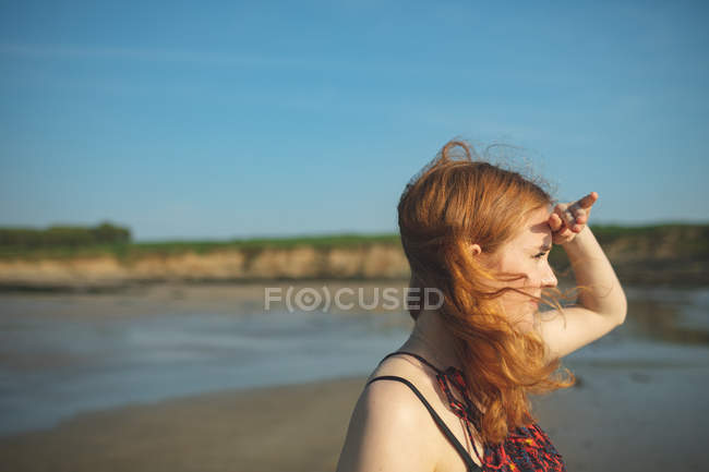 Nahaufnahme einer Frau, die an einem sonnigen Tag aufs Meer blickt — Stockfoto