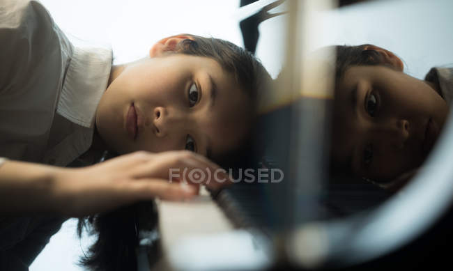Adorable schoolgirl playing piano in music school — Stock Photo