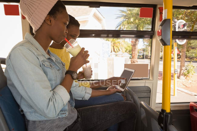 Twins siblings using digital tablet in the bus — Stock Photo
