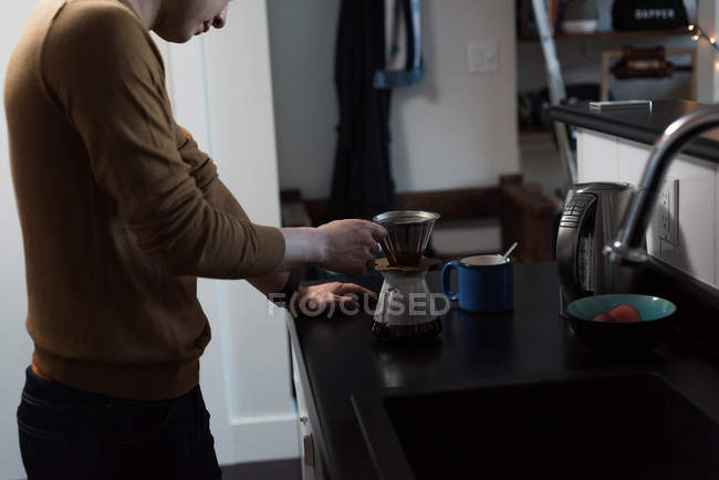 Man preparing black coffee in the kitchen at home — Stock Photo
