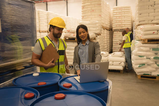 Staff interacting with each other over laptop in warehouse — Stock Photo
