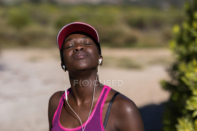 Exhausted female athlete relaxing with her eyes closed — Stock Photo
