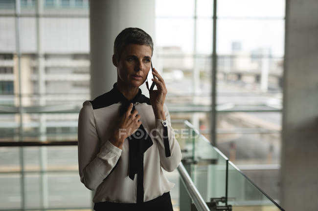 Geschäftsfrau telefoniert im Büro mit dem Handy — Stockfoto
