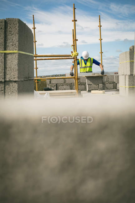Ingénieur effectuant une vérification au niveau du mur sur le chantier de construction — Photo de stock