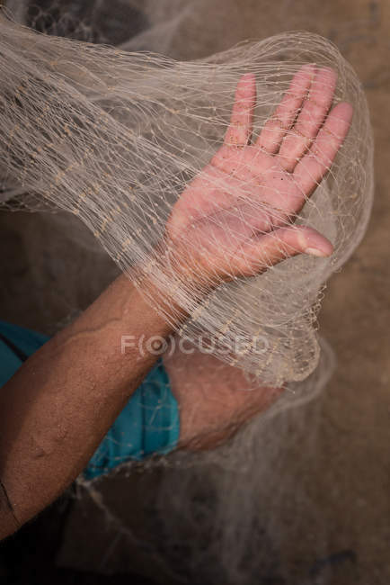 Mid section of fisherman holding fishing net — Stock Photo
