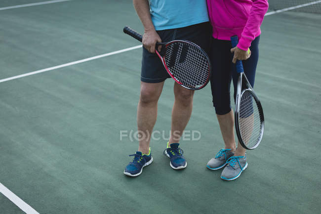Section basse du couple de personnes âgées debout dans le court de tennis — Photo de stock