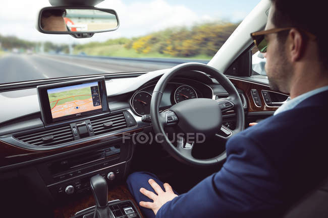 Hombre de negocios inteligente conduciendo un coche - foto de stock