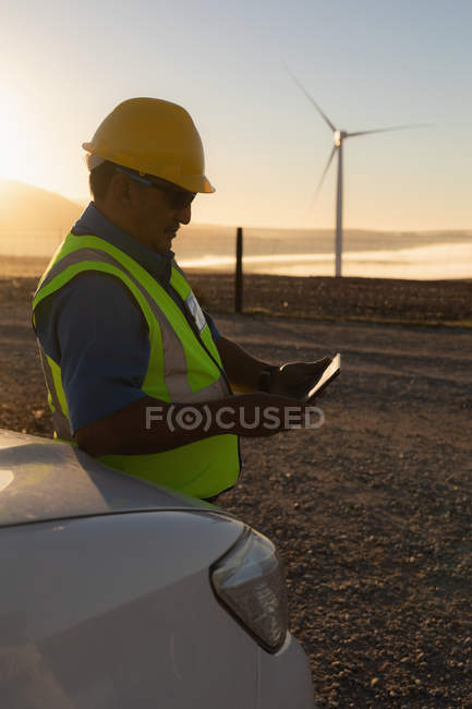 Ingénieur utilisant une tablette numérique dans un parc éolien — Photo de stock