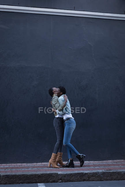 Близнюки брати і сестри обіймаються один одного на тротуар в міській вулиці — стокове фото