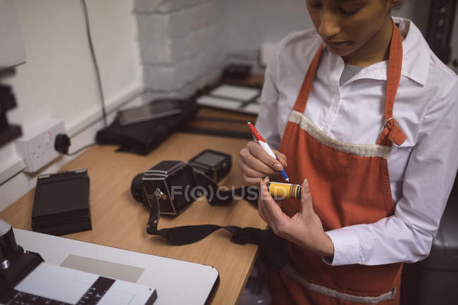 Photographe femelle marquant une bobine de photo en studio photo — Photo de stock