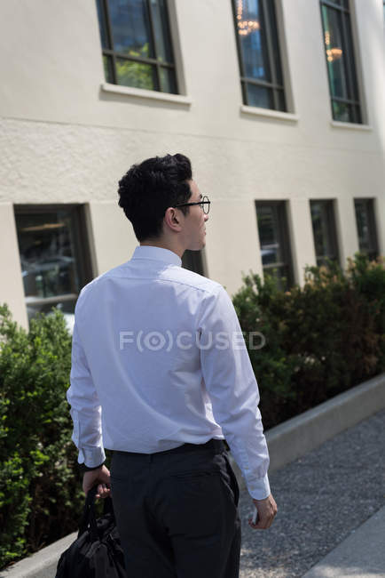 Rear view of man with bag walking to office — Stock Photo