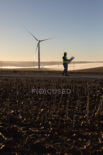 Інженер, що тримає схему на вітроелектростанції — стокове фото