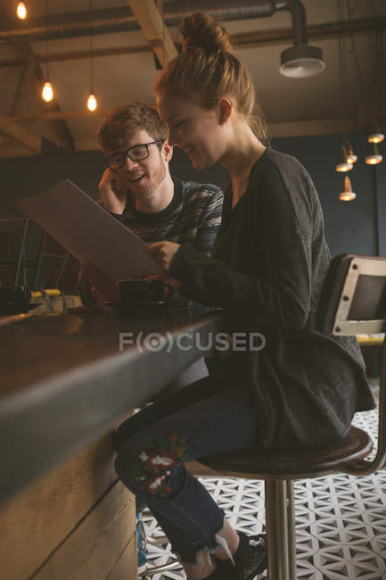 Casal jovem checando o cartão de menu no restaurante — Fotografia de Stock
