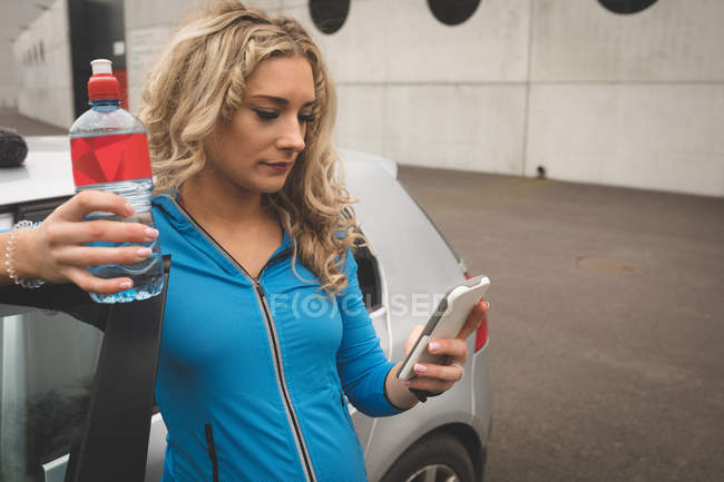 Красива вагітна жінка використовує мобільний телефон у парковці — стокове фото