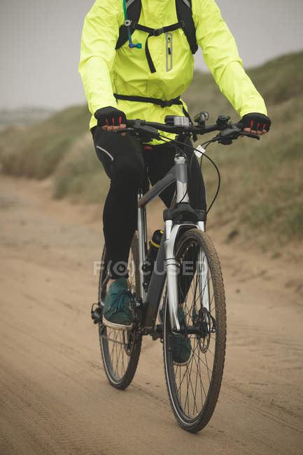 Bassa sezione di uomo in bicicletta in spiaggia durante l'esercizio — Foto stock