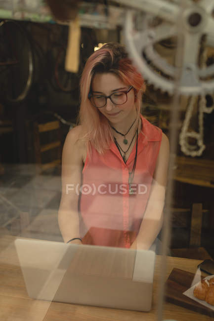 Молодая женщина использует ноутбук в кофейне — стоковое фото