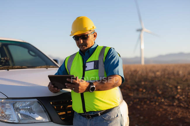 Engineer using a digital tablet at a wind farm — Stock Photo