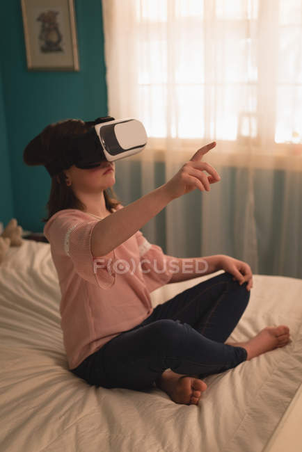Дівчина за допомогою віртуальної реальності гарнітуру в спальні в домашніх умовах — стокове фото