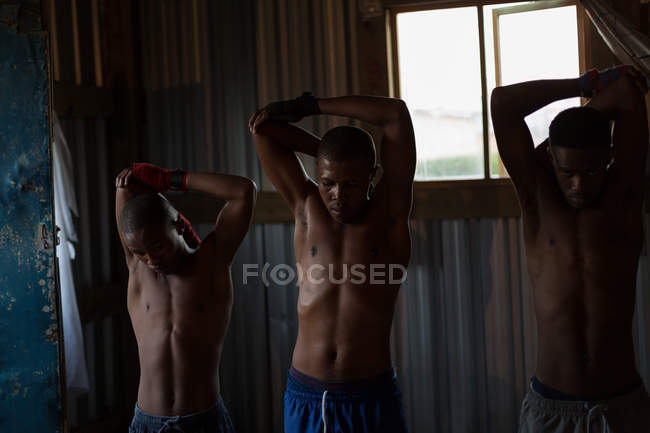Jóvenes boxeadores masculinos ejercitándose en gimnasio - foto de stock