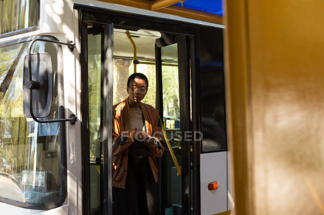 Woman getting out from the bus at bus stop — Stock Photo