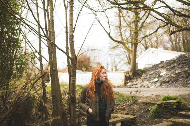 Красиве руде волосся жіночий пішохід, який озирається в лісі — стокове фото