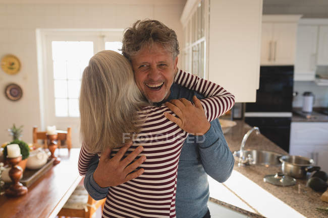 Romantiche coppie di anziani che si abbracciano in cucina — Foto stock