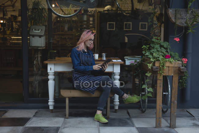 Junge Frau mit Tablet vor Café — Stockfoto