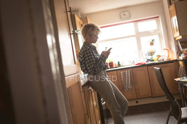 Молода жінка використовує мобільний телефон вдома — стокове фото