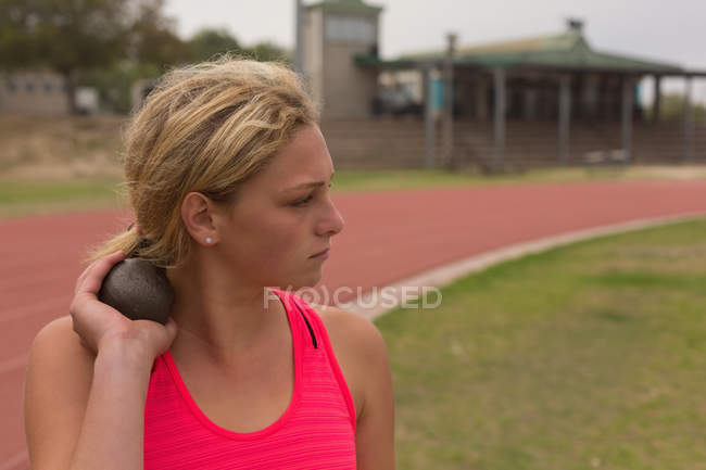 Female athlete practicing shot put at sports venue — Stock Photo