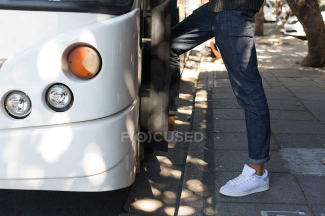 Baixa seção de homem embarque ônibus na parada de ônibus — Fotografia de Stock