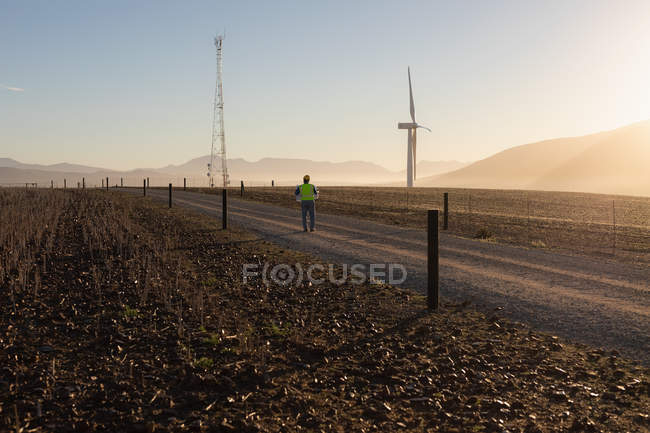 Вид спереду інженера, що ходить на вітроелектростанції — стокове фото