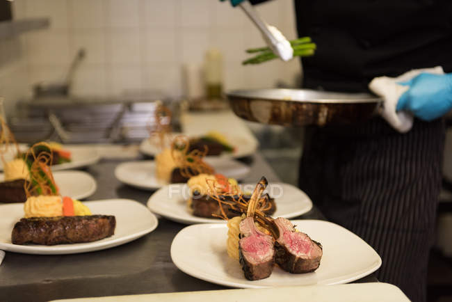 Männlicher Koch serviert Essen in einem Teller im Restaurant — Stockfoto