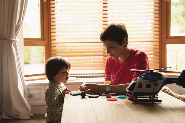 Мати грає з сином на столі вдома — стокове фото