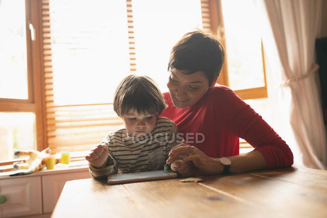 Mutter unterrichtet Sohn zu Hause auf digitalem Tablet — Stockfoto