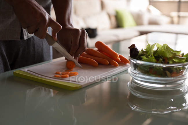 Metà sezione di donna taglio insalata in cucina a casa — Foto stock