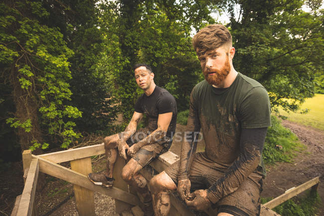 Fit men relaxing over obstacle course at boot camp — Stock Photo