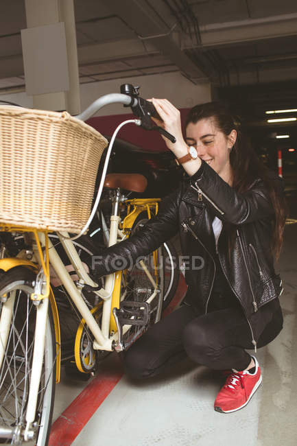 Mulher bonita estacionando sua bicicleta — Fotografia de Stock